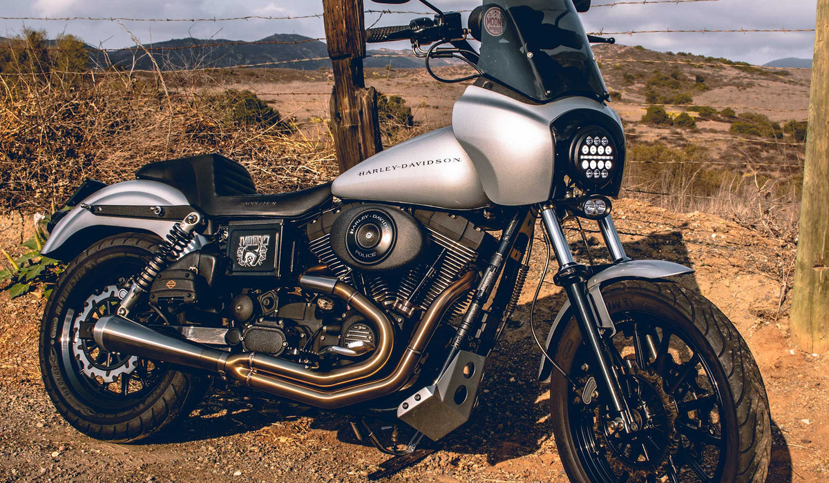 Silver Harley-Davidson Dyna with MOONSMC LED lighting beside a country road