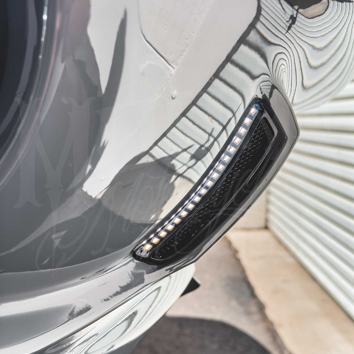 Close-up of an FXLRST LED vent light installed in a gray motorcycle fairing.