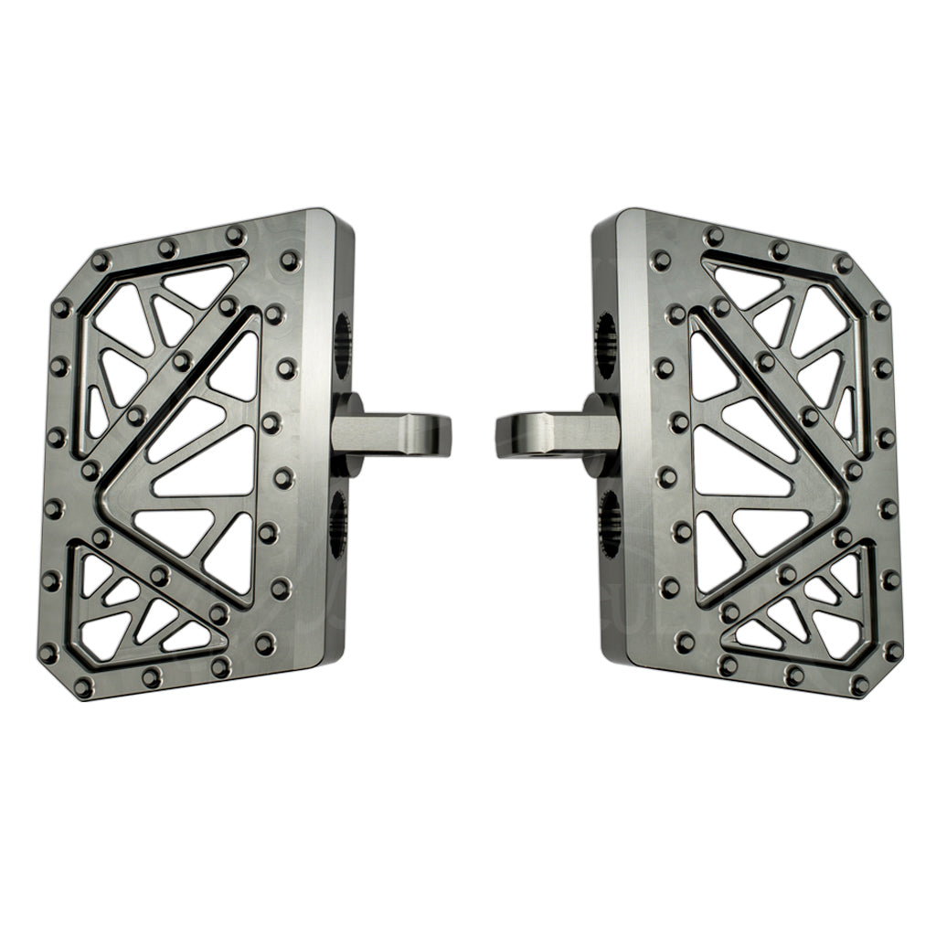 Pair of gray MOONSMC mini floorboards for Dyna, FXR and Sportster, showing geometric cutouts and traction pins.