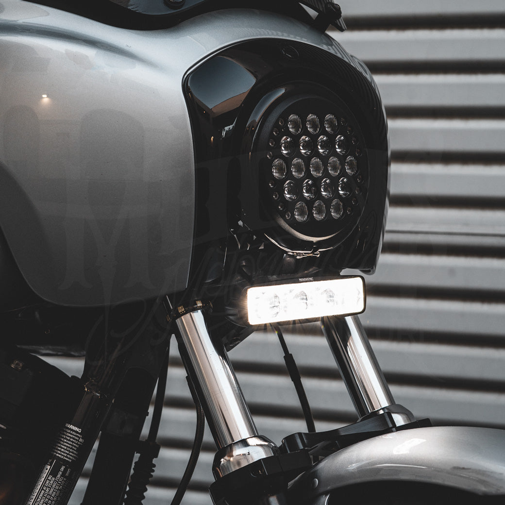 V3 LED light bar illuminated white beneath a round motorcycle headlight.