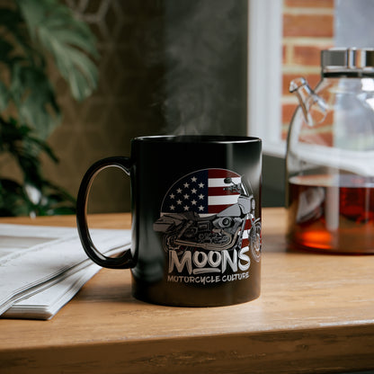 MOONSMC FXDT / T-SPORT MURICA 11oz Black Mug: printed black mug on a wooden table beside an open book.