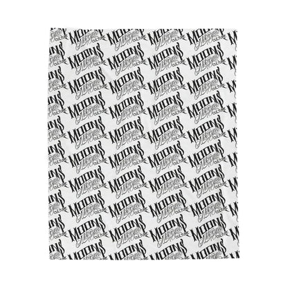 MOONSMC OG Logo plush blanket laid flat, showing diagonal rows of black logos on white fabric.