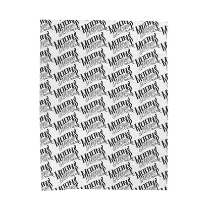 MOONSMC OG Logo plush blanket laid flat, showing diagonal rows of black logos on white fabric.