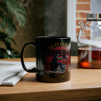 MOONSMC FXRT Sunset 11oz Black Mug: printed black mug on a wooden table beside an open book.