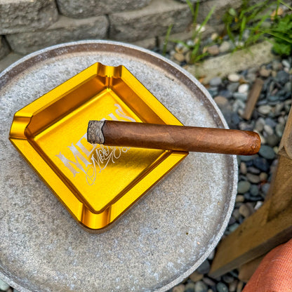 MOONSMC "The Diplomat" Cigar Ashtray: top view of a gold tray holding a cigar.