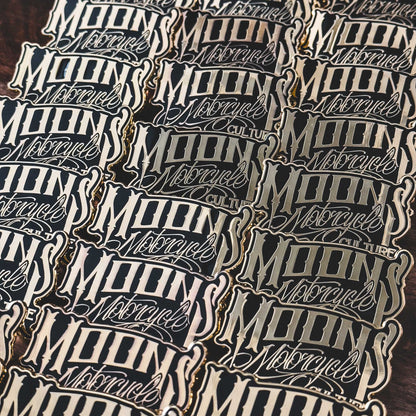 MOONSMC OG Logo Black & Gold Enamel Collector Pin: group of logo pins arranged together.