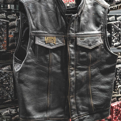 MOONSMC OG Logo Black & Gold Enamel Collector Pin: black leather vest with the logo pin on its chest pocket.