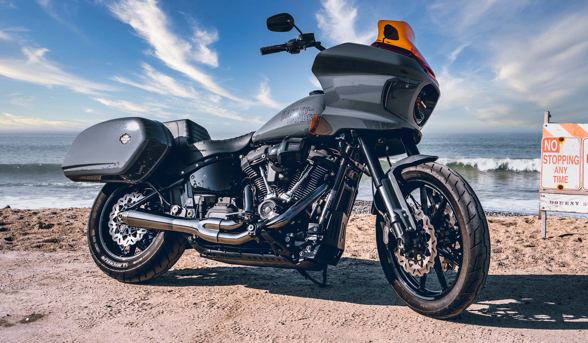 Gray Harley-Davidson Low Rider ST with MOONSMC lighting beside the ocean