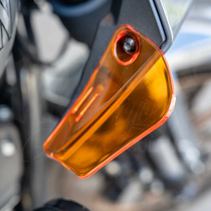 Close-up of an orange MOONSMC air deflector installed on a Softail FXLRST fairing.