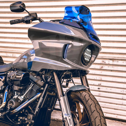 Blue MOONSMC 8.5-inch recurve windshield installed on a gray Softail FXLRST fairing.