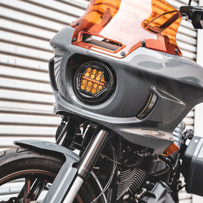 Front view of an amber HexBeam Pro headlight installed in a gray fairing with an orange windshield.