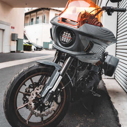 Front three-quarter view of a motorcycle fitted with a clear-lens HexBeam Pro headlight and gray fairing.
