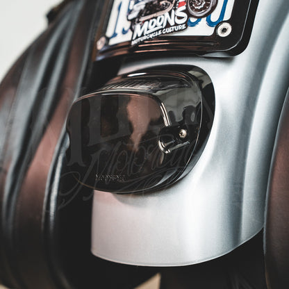 Smoked V4 tail light installed beneath a license plate on a silver motorcycle rear fender.