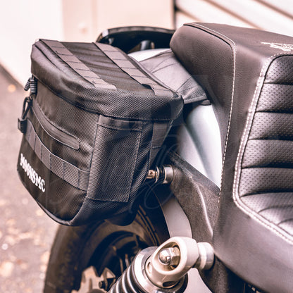 Close-up of a MOONSMC RECON saddlebag installed beside a motorcycle seat.