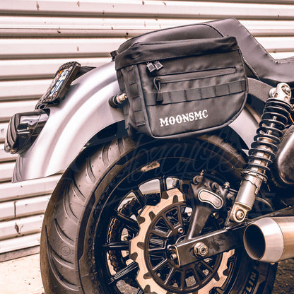 MOONSMC RECON saddlebag mounted beside a motorcycle rear wheel and shock.