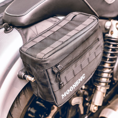Top and front view of an installed MOONSMC RECON saddlebag showing webbing on the lid.
