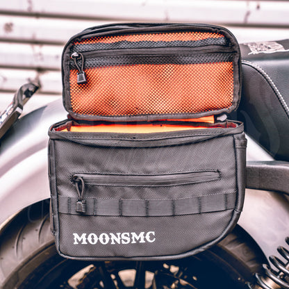 Installed MOONSMC RECON saddlebag with its lid open, showing orange lining and a mesh pocket.