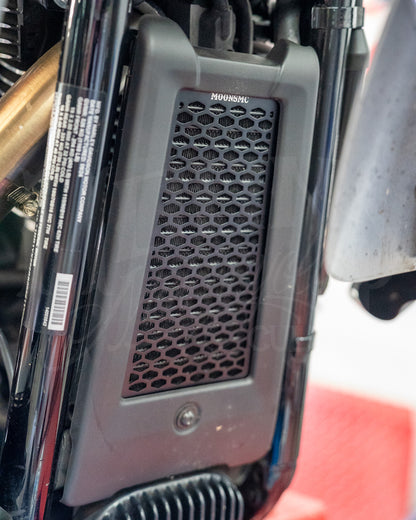 Black MOONSMC honeycomb oil cooler guard installed at the front of a Softail M8.