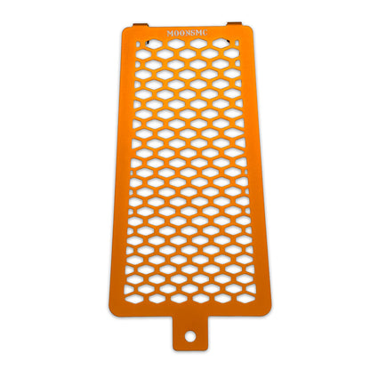 Front view of the orange MOONSMC Softail M8 oil cooler guard with a honeycomb pattern.